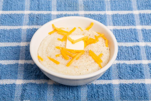 Grãos em tigela branca com queijo e manteiga — Fotografia de Stock