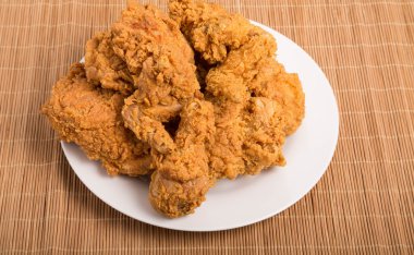 Fried Chicken bambu hasır üzerinde beyaz tabak
