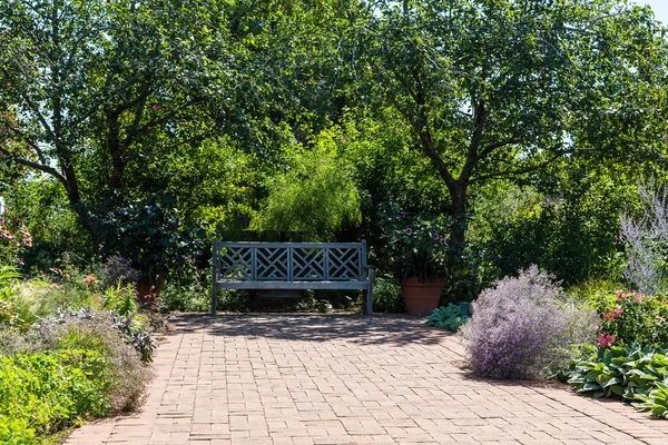 Banc en bois sur la passerelle en brique dans le jardin public — Photo