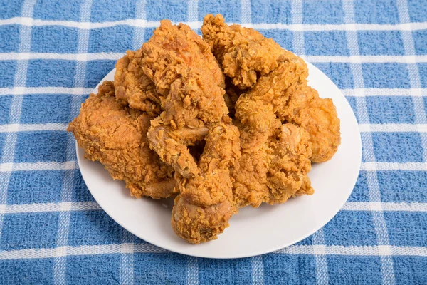 Placa branca de frango frito na toalha azul — Fotografia de Stock