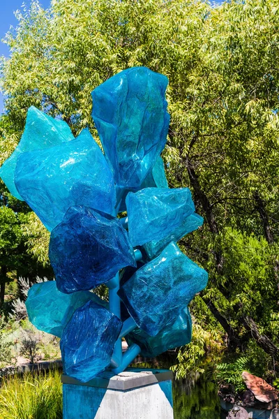 Sculpture en verre bleu dans le jardin public vert — Photo