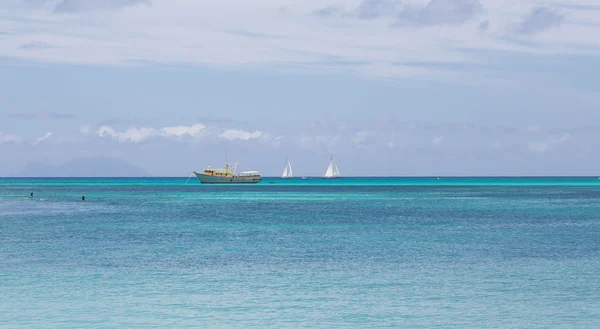 Bateau de pêche jaune et deux voiliers — Photo