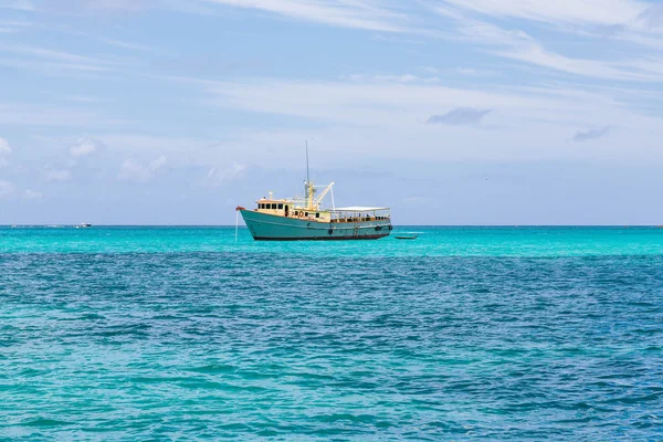 Barco de pesca amarelo e branco em água do Aqua — Fotografia de Stock