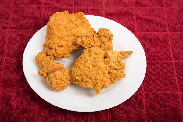 Жареный цыпленок на белой тарелке и красном полотенце — стоковое фото