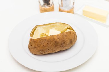Tuz ve biber arka planda tereyağlı fırında patates