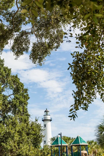 Parque infantil e árvores com farol no fundo — Fotografia de Stock