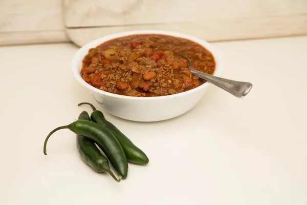 Vit skål med Chili med tre Jalapenos — Stockfoto