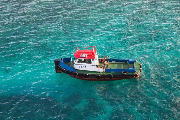 Červená bílá a modrá lodivodův člun v Aqua voda — Stock fotografie