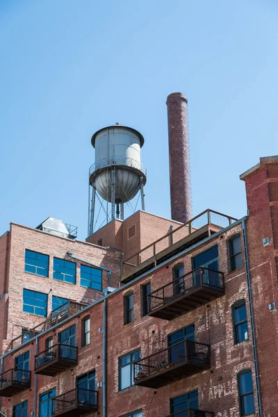 Wieża ciśnień na starym budynku z cegły z balkonów metalowych — Zdjęcie stockowe