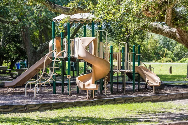 Зеленая и коричневая игровая площадка в общественном парке — стоковое фото