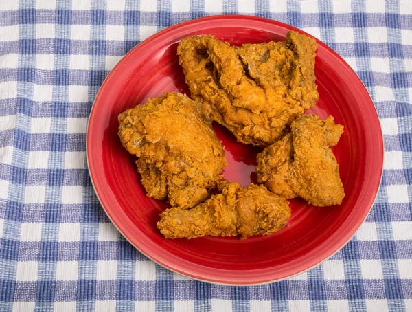 Halbes Huhn auf rotem Teller — Stockfoto