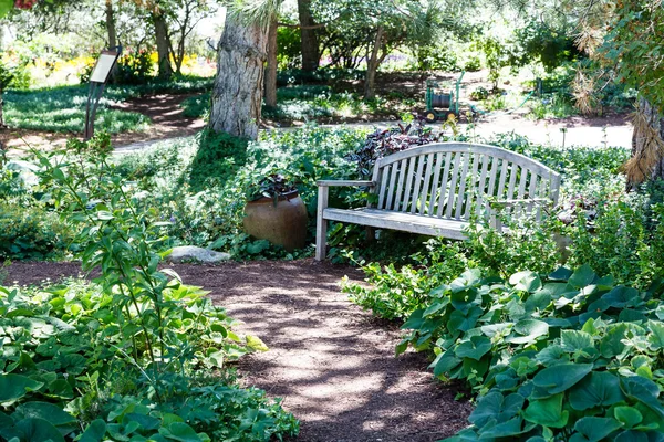 Panca in legno lungo il percorso del giardino — Foto Stock