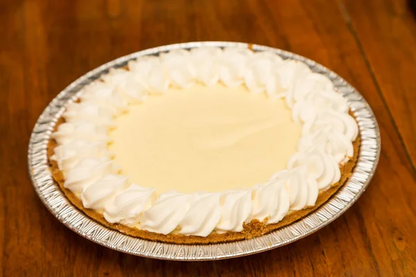 Ganze Zitronenbaiser-Torte auf Holztisch — Stockfoto