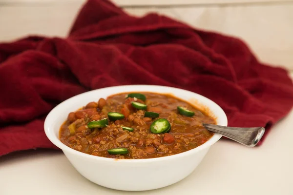 Vit skål med Chili med skivad Jalapenos och röd handduk — Stockfoto