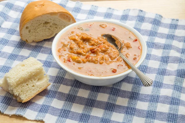 Skål med soppa med bröd i fönster ljus — Stockfoto