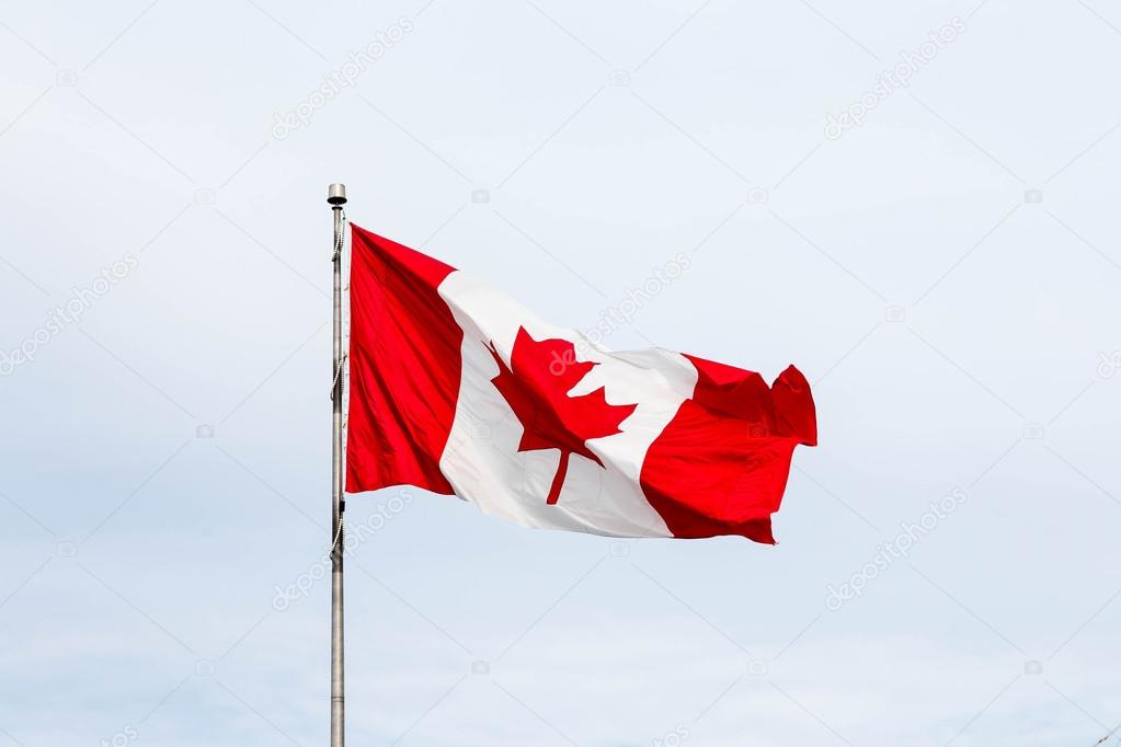 Canadian Flag Flying Under Clouds
