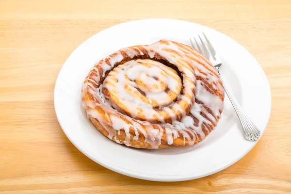 Kanelbulle på tallrik med gaffel — Stockfoto