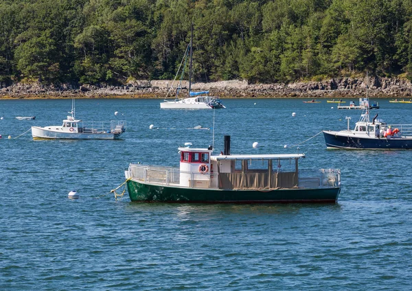 Старые лодки и новый катамаран — стоковое фото