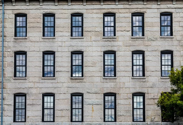 Osmnáct oken v žulových blok zeď — Stock fotografie