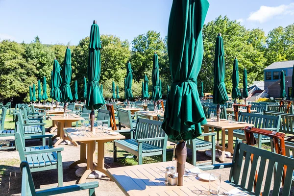 Mesas al aire libre con sombrillas y sillas verdes —  Fotos de Stock