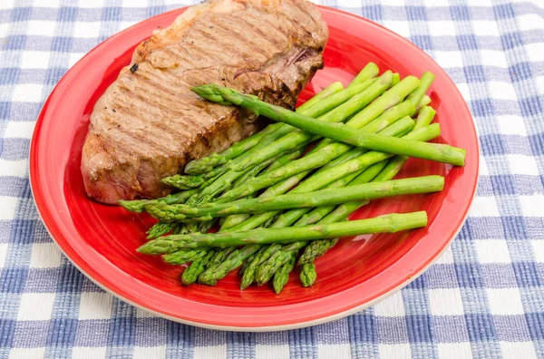 Strip Steak and Asparagus on Red Plate — Stock Photo, Image