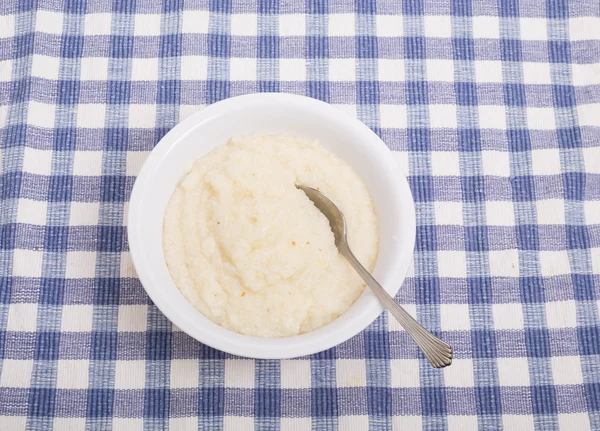 Kom van witte grutten op blauwe selectievakje tafellaken — Stockfoto