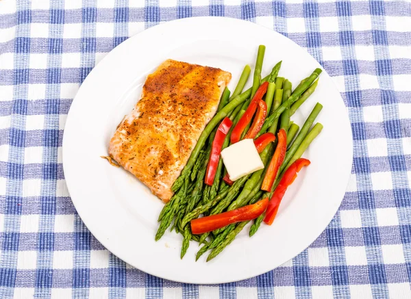 Salmão assado com espargos e pimentas vermelhas com manteiga — Fotografia de Stock