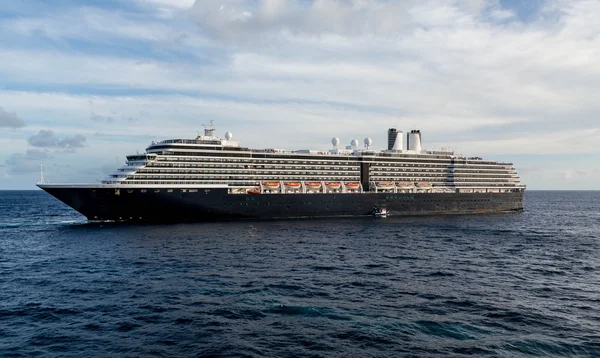 Lotsenboot von massivem schwarz-weißem Kreuzfahrtschiff — Stockfoto