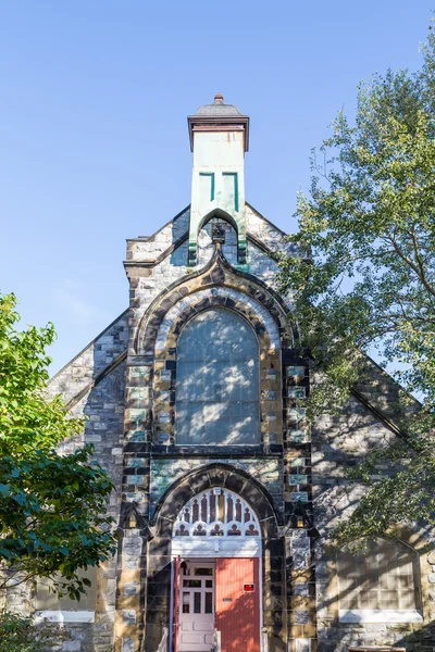 Eglise en pierre avec porte rouge ouverte dans la lumière applaudie — Photo