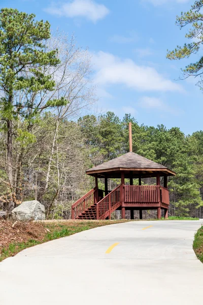 Gazebo de madera en el parque más allá del camino concreto —  Fotos de Stock