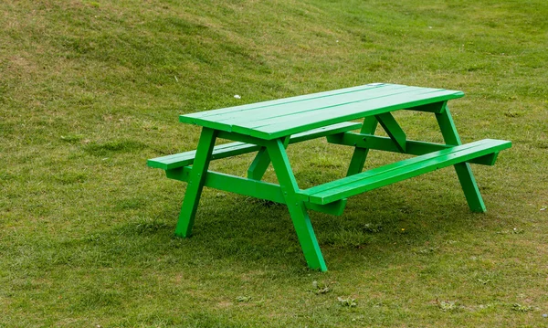 Zelený stůl na zelené trávě — Stock fotografie