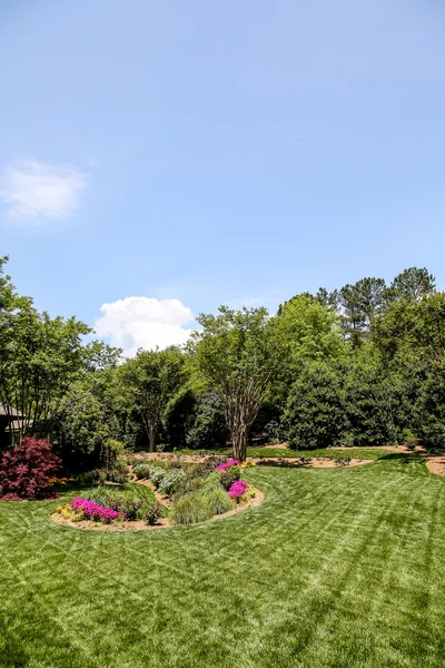 Välklippta gräsmattan runt formell trädgård — Stockfoto