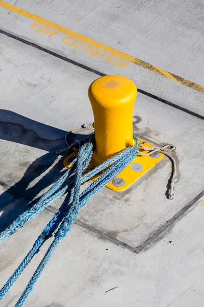 Drei blaue Seile auf gelbem Poller — Stockfoto