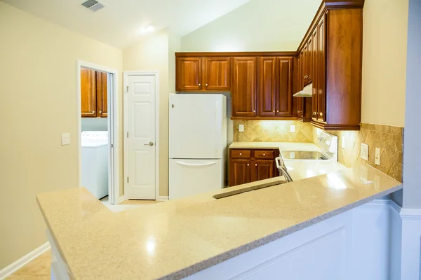 Countertops van de grainite in heldere nieuwe keuken — Stockfoto