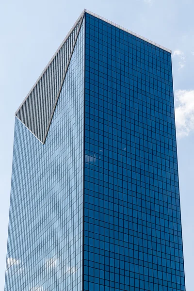 Облака, отраженные в голубой башне с треугольным дизайном — стоковое фото