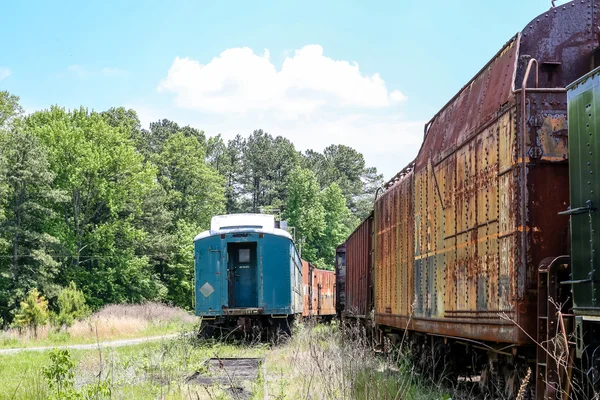Blå järnväg bil med Rusty tåg — Stockfoto