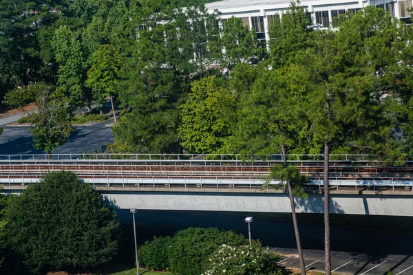 Rapid Transit spoorlijn door bomen en gebouw — Stockfoto