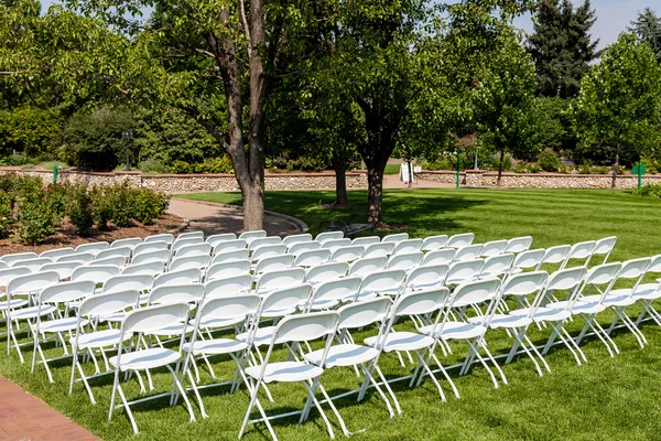 Λευκό διπλώνοντας καρέκλες για πράσινο γκαζόν — Φωτογραφία Αρχείου