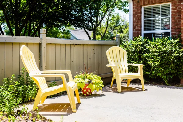 Gele Adirondack stoelen op Patio — Stockfoto