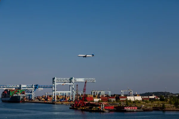 Letadlo nad nákladní lodní přístav — Stock fotografie