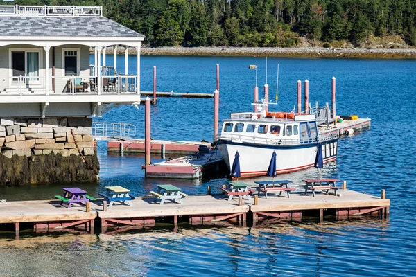 Boot am Steg mit bunten Picknicktischen — Stockfoto