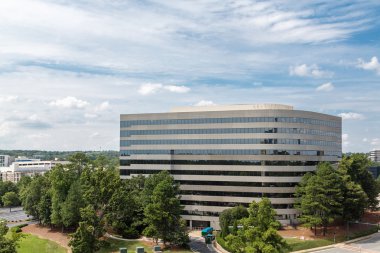 Kavisli beton bina ağaçları arasında