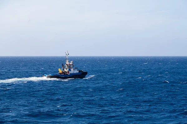 Tugboat azul que se dirige hacia fuera sobre mar azul — Foto de Stock