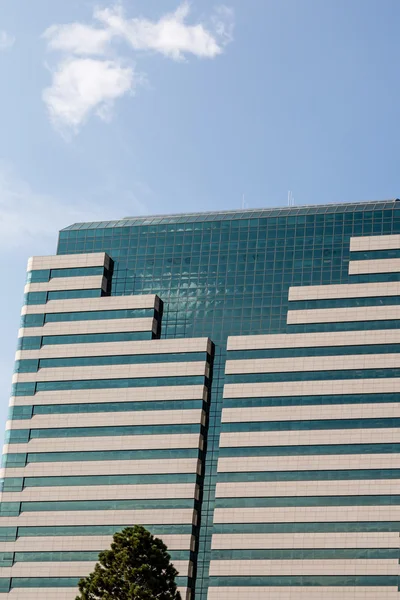 Pedra clássica e edifício de vidro azul sob céu ensolarado — Fotografia de Stock