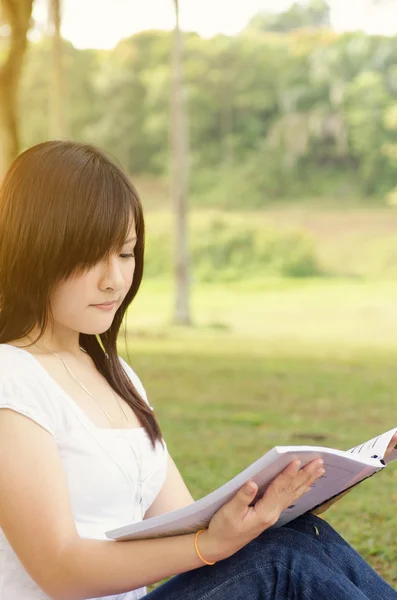 Young Asian college student reading book — Stock Photo, Image