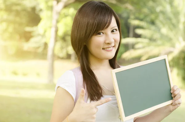 Asiatiska collegestudent pekar på tomma svarta tavlan — Stockfoto