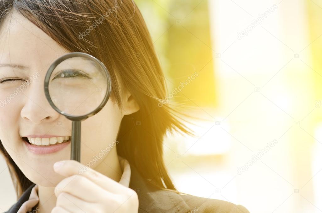 Asian female searching with magnifier