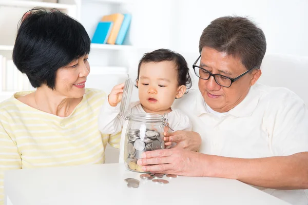 Aziatische familie opslaan munten — Stockfoto