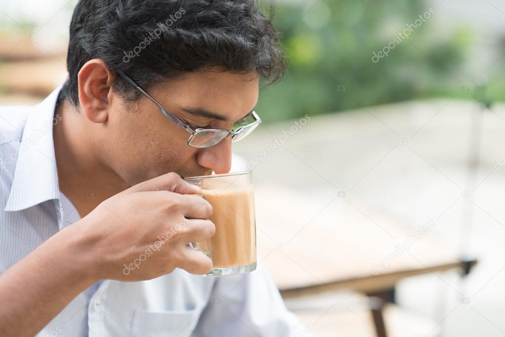 Indian businessman sipping a cup hot milk tea 