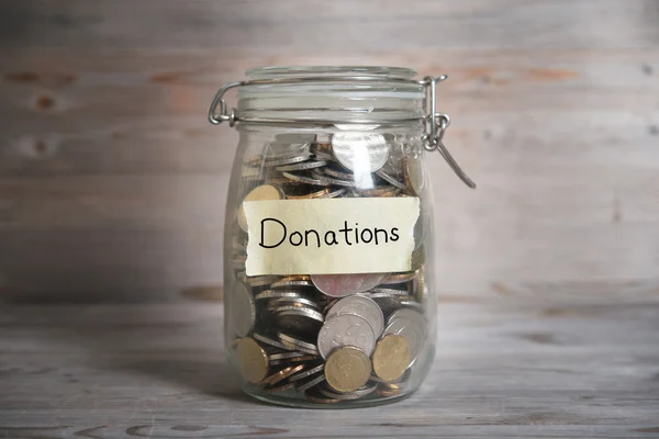 Money jar with donations label. — Stock Photo, Image